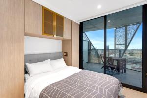 um quarto com uma cama e uma varanda com uma mesa em NEW Skyline View Luxury Apt Homey Heart of ADL em Adelaide