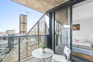 a room with a balcony with a bed and a table at Taffy on Realm RundleMall Pool&Gym EasyLifestyle in Adelaide