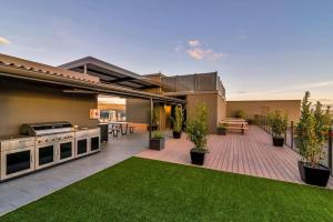 a backyard with a grill and a patio with grass at Walk to Central Market Parking GYM&POOL City View in Adelaide