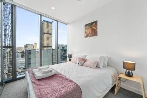 a bedroom with a white bed and a large window at Taffy on Realm RundleMall Pool&Gym EasyLifestyle in Adelaide