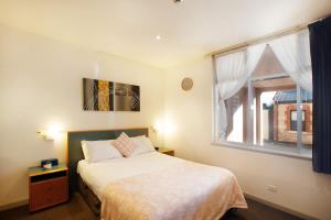 a small bedroom with a bed and a window at CBD premium location Studio in Adelaide