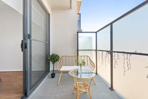 a balcony with a glass table and a chair at New Luxury Stylish Elegant Townhouse for Families in Broadview