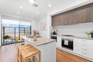 a kitchen with white cabinets and a counter top at New Luxury Stylish Elegant Townhouse for Families in Broadview