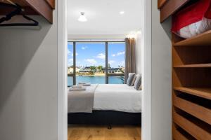 a bedroom with a bed with a view of the water at Amazing Lakeside View Townhouse-Dream Staycation in Cheltenham