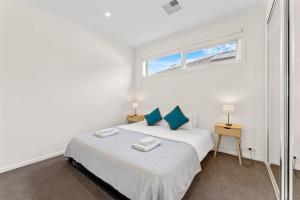 a white bedroom with a bed and a window at Amazing Lake View family-friendly Holiday Home in Cheltenham