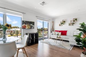 a living room with a white couch and a fireplace at Lovely Renovated 2BR Townhouse WiFi Parking in Sturt