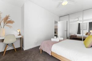 Schlafzimmer mit einem Bett, einem Schreibtisch und einem Stuhl in der Unterkunft 1BR Adelaide CBD Apt The Best Location in Adelaide