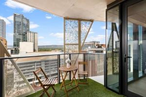 un balcón con 2 sillas y una mesa en un edificio en The 2BR City Escape - Stylish and Mordern en Adelaida