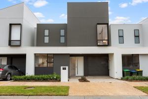 CampbelltownWoodforde 3BR house with an amazing view的前面有一辆汽车停放的灰色房子