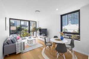 a living room with a couch and a table at Surf's Up Stunning Paradise Apartment Serenity in Gold Coast