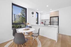 a kitchen and dining room with a table and chairs at Surf's Up Stunning Paradise Apartment Serenity in Gold Coast