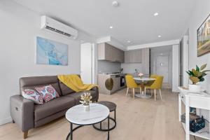 sala de estar con sofá y mesa en Adelaide CBD Oasis - 2BR Realm Retreat - Level 19 en Adelaida