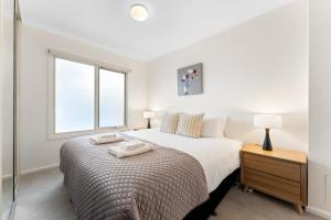 a bedroom with a bed with two towels on it at Family friendly CBD 3BR Apt Hurtle Square in Adelaide