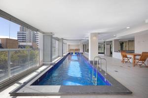 a swimming pool in a building with a large window at CBD 2BR Apartment at 96 North Tce - Free Parking in Adelaide