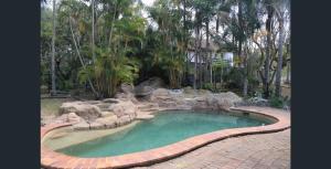 a small pool in a backyard with a rock garden at The 2BR Farm Escape idyllic scenery peaceful tour in Gold Coast