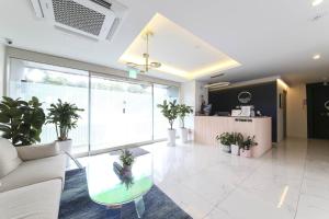 a lobby with a couch and a table and potted plants at ND 1226 Hotel in Busan