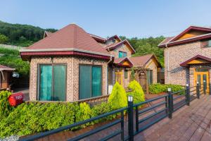 a brick house with a fence in front of it at Gapyeong hatteuneun supsok pension in Gapyeong