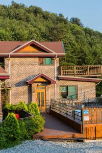 a brick house with a deck and a balcony at Gapyeong hatteuneun supsok pension in Gapyeong +6 photos