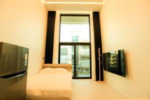 a bedroom with a tv and a bed and a window at Daecheon Golden Rose Pension in Boryeong