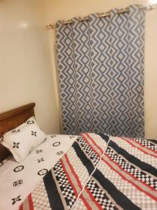 a bed with a quilt and pillows on it at Appartement meublé in Dakar