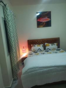 a bedroom with a bed and a lamp next to it at Appartement meublé in Dakar