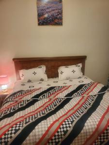 a bed with two pillows and a picture on the wall at Appartement meublé in Dakar