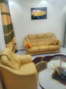 a living room with two chairs and a couch at Appartement meublé in Dakar