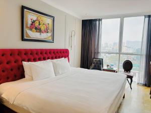 Le Grand Hanoi Hotel - The Sun في هانوي: غرفة في الفندق مع سرير كبير مع اللوح الأمامي الأحمر