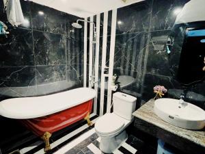 Le Grand Hanoi Hotel - The Sun في هانوي: حمام به مرحاض أبيض ومغسلة