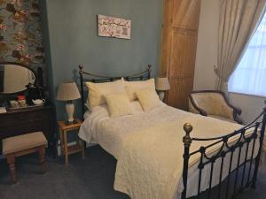 a bedroom with a large bed and a mirror at Mostyn House in Llandudno
