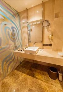 a bathroom with a sink and a large mirror at Hotel BENTLY Terminal-2 in Mumbai