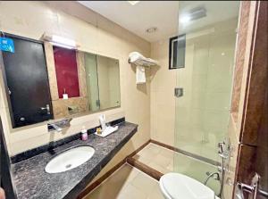 a bathroom with a toilet and a sink and a shower at Hotel BENTLY Terminal-2 in Mumbai
