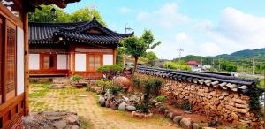 宝城郡boseong sujinhanog pensyeon的一栋有石墙和植物的亚洲房屋
