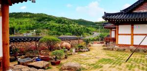 宝城郡boseong sujinhanog pensyeon的一座带石墙的建筑前的花园