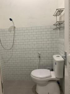 een witte badkamer met een toilet en een douche bij Resy home syariah family room dekat alun2 wonosobo in Kalianget