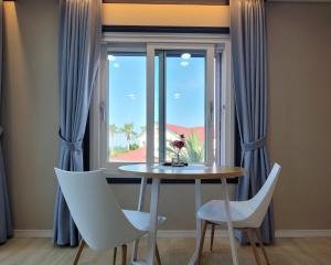 a table and chairs in front of a window at Jeju the Aewol Pension in Jeju