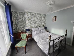- une chambre avec un lit, une chaise et un bureau dans l'établissement Mostyn House, à Llandudno