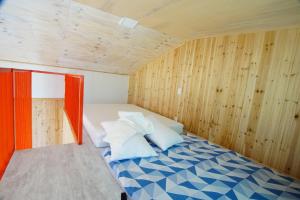a bed in a small room with wooden walls at ganghwa mj hauseu in Incheon +27 photos