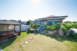 a house with a garden in front of it at Ulsan Healing Dokchae Pension in Ulsan