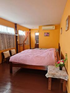 um quarto com uma cama grande num quarto com paredes amarelas em Lamour Guesthouse ละเมอ เกสต์เฮาส์ em Pattaya North