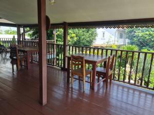 um alpendre com uma mesa de madeira e cadeiras numa varanda em Lamour Guesthouse ละเมอ เกสต์เฮาส์ em Pattaya North
