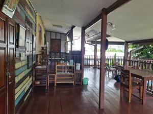 um quarto com pisos e mesas e cadeiras em madeira em Lamour Guesthouse ละเมอ เกสต์เฮาส์ em Pattaya North