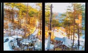 una vista di una finestra con una panchina nella neve di Byeoldeul-ui Gichim Pension a Inje
