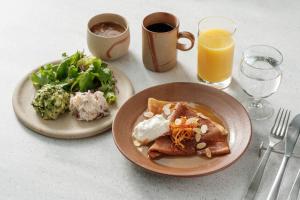 広島市にあるKIRO 広島 by THE SHARE HOTELS のテーブル(2皿分の食べ物とオレンジジュース1杯付) +37枚の写真