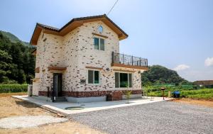 a building that is sitting on a gravel lot at Poolip Family House in Gapyeong