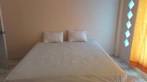 Bett in einem Zimmer mit zwei Kissen darauf in der Unterkunft Homestay visit in Klapa