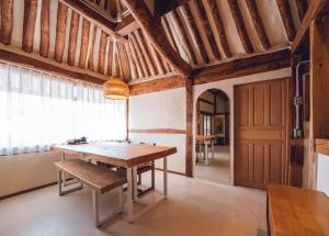 a dining room with a wooden table and a bench at Goheung Namsoonjae Hanok Stay in Goheung