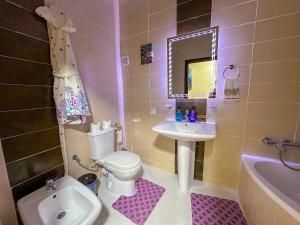 a bathroom with a toilet and a sink and a mirror at LovelyStay - Luxury & proximity to Corniche and TGV in Tangier