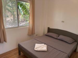 Una cama con una toalla en un dormitorio en Annabel's Resort, en Ferrol