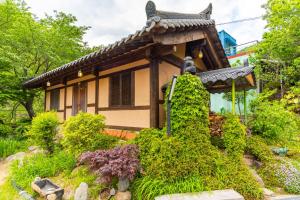a garden with a small house in the background at Hadong kkotdam pension in Hadong